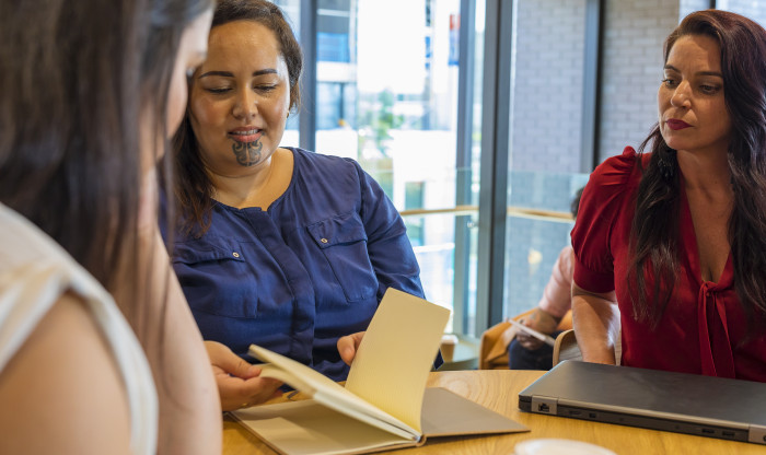 Three people sitting at a table having a discussion