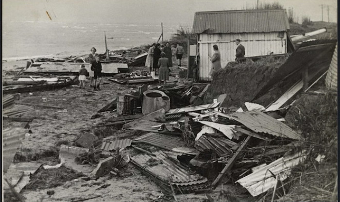 Historic black and white image showing destruction and rubble on the beach after earthquake