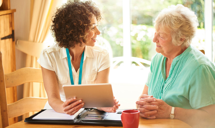 Two people talk through documents at a table