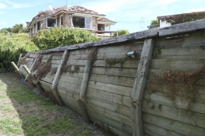 wooden retaining wall is bulging and broken