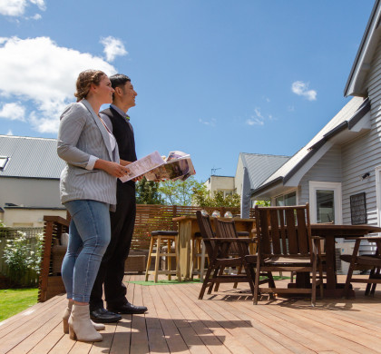 Two people looking at a house for sale