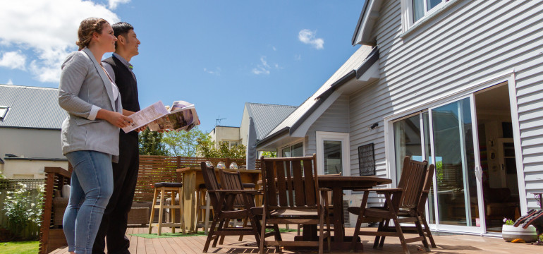 Two people looking at a house for sale