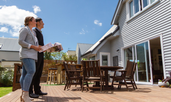 Two people looking at a house for sale