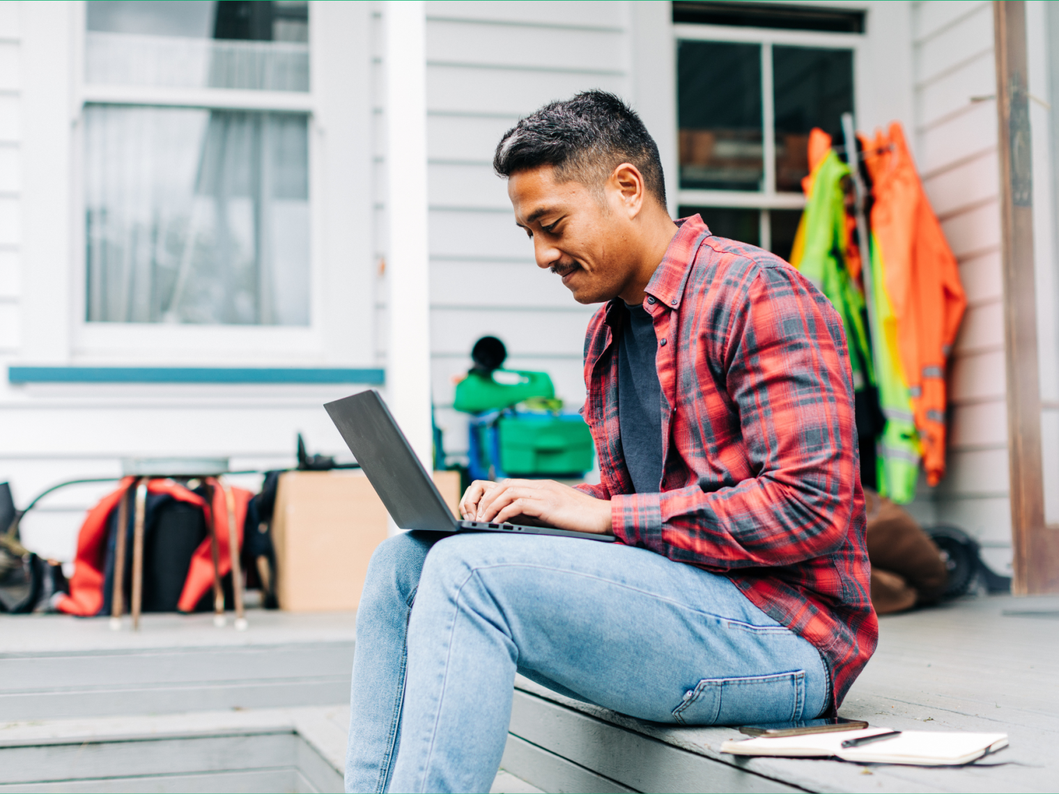 Homeowner sits outside his home on his laptop researching his natural hazard risk