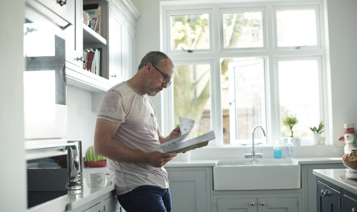 man reads document in the kitchen