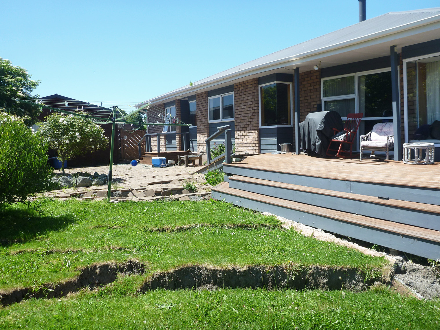 House with earthquake damage on the front lawn