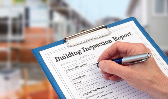 Close up of a builders hands filling in a building inspection report